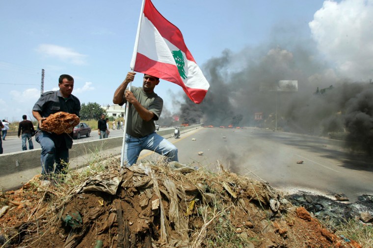 Image: Pro-government loyalists plant a Lebanese flag